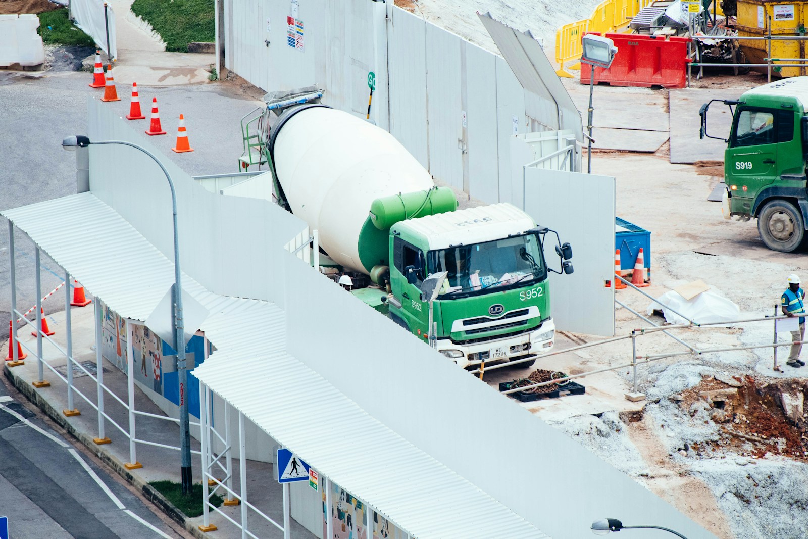 green and white mixer truck at the construction site